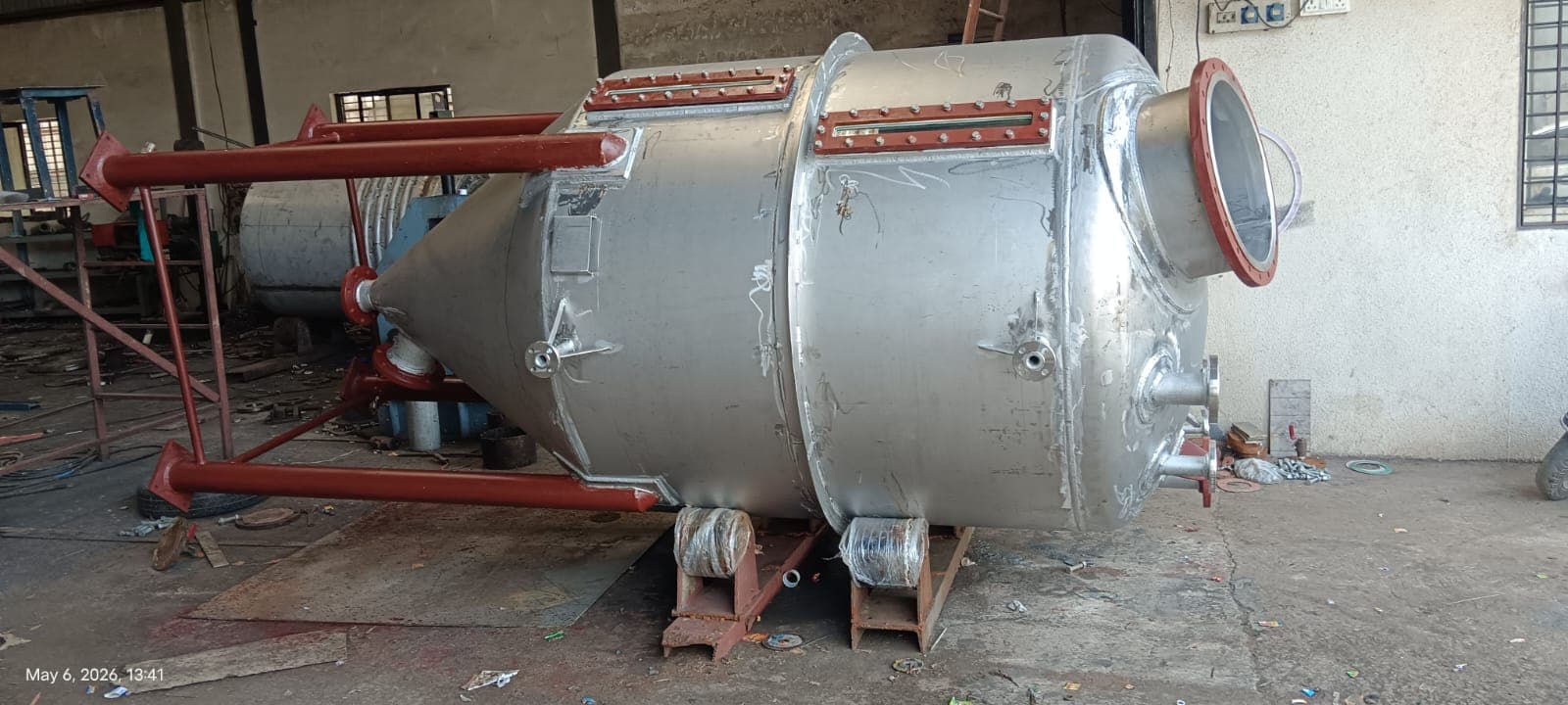 Process vessel with a conical bottom and support legs in a workshop