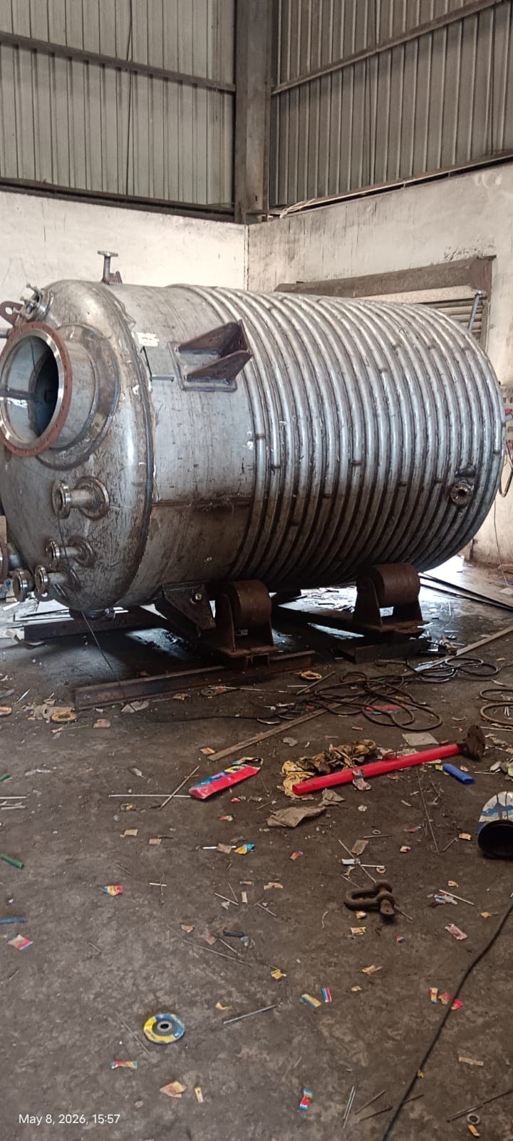 Jacketed process vessel resting on saddles in a fabrication workshop