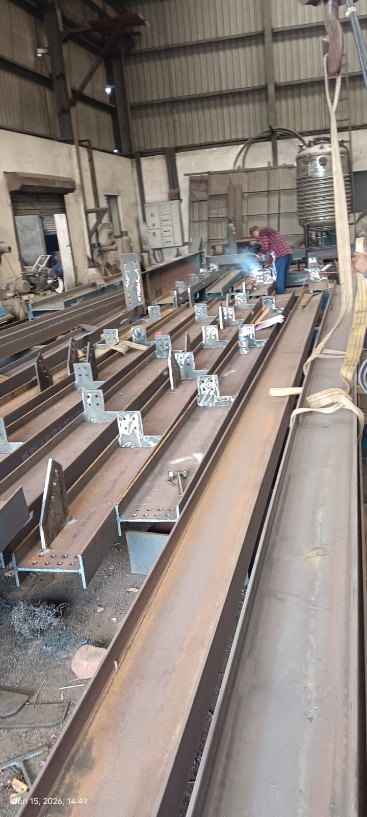 Structural beams with welded brackets being fabricated in a workshop